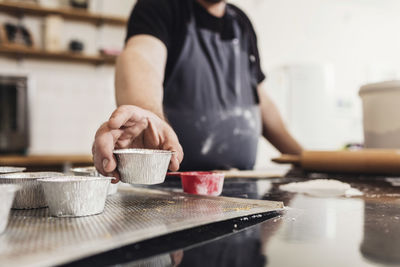 Low angle view of man holding bowl at kitchen counter