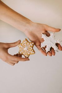 Close-up of hand holding paper over white background