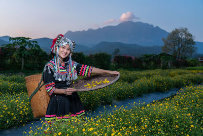 Portrait of woman holding umbrella while standing on field