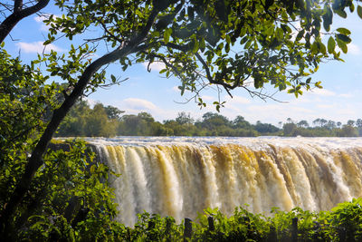 Scenic view of waterfall against sky, victoria falls