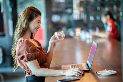 Woman with coffee cup on table at cafe