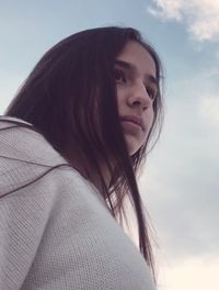 Portrait of beautiful young woman against sky