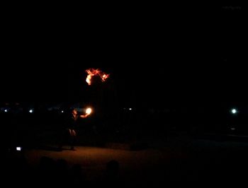 Man against illuminated sky at night