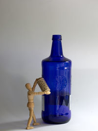 Close-up of blue water bottle on table against white background