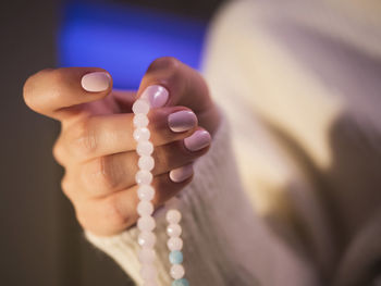 Cropped image of woman holding rosary beads