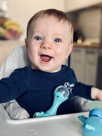 Cute baby in high chair at home