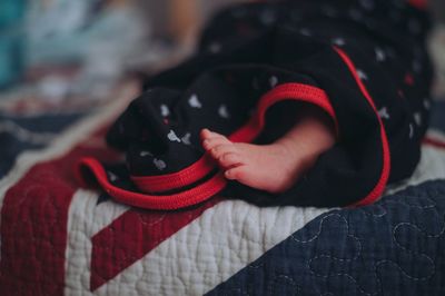 Low section of baby on bed at home