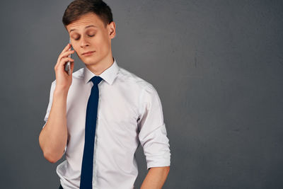 Young man standing against wall