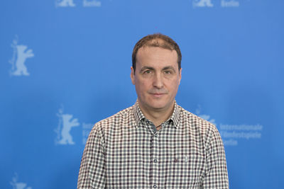 Portrait of man standing against blue sky