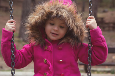 Portrait of cute girl on swing at playground