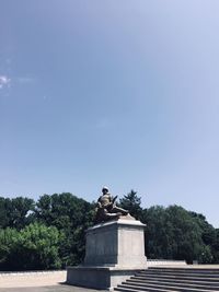 Low angle view of statue against clear blue sky