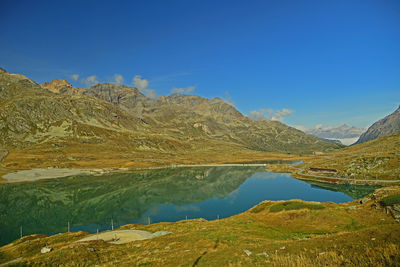 Scenic view of lake and mountains against blue sky