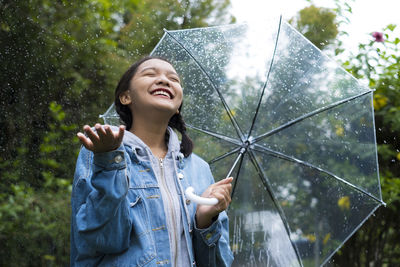 Woman standing on wet glass during rainy season