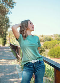 Middle aged women wearing t-shirt and jeans stays outdoor in the park 