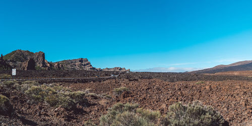 Scenic view of rocky mountains against blue sky