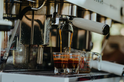 Espresso shot coffee flows from the coffee machine.