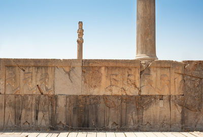 Ruins of apadana and tachara palace behind stairway with bas relief carvings in persepolis unesco