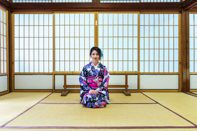 Portrait of woman kneeling at home