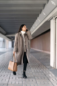 Full length of woman walking on footpath