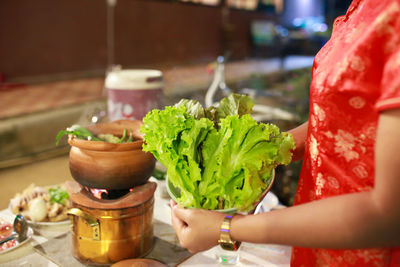 Midsection of woman holding potted plant