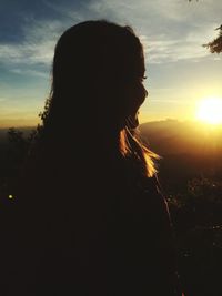 Silhouette woman against sky during sunset