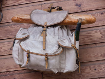 Directly above shot of bag with bread loaf and wine bottle on table