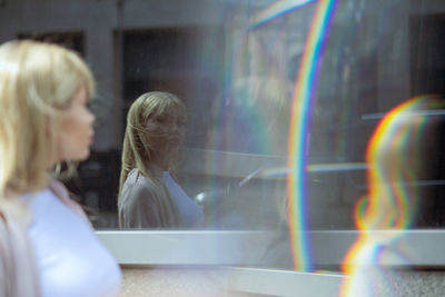 Double exposure of beautiful young woman standing in front of building