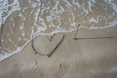 High angle view of heart shape on sand at beach