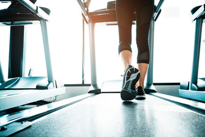 Low section of woman on treadmill in gym