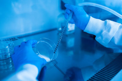 Cropped hand of scientist examining chemical in laboratory