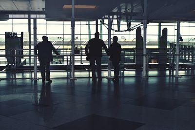 Rear view of silhouette people walking in airport