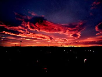 Silhouette landscape against dramatic sky during sunset