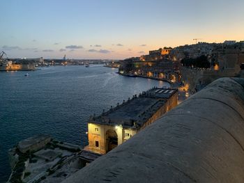 High angle view of buildings by sea during sunset