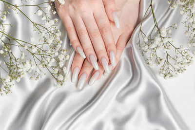 Cropped hand of woman with iv drip on bed