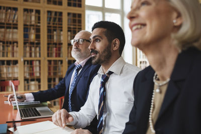 Male and female professionals listening in meeting