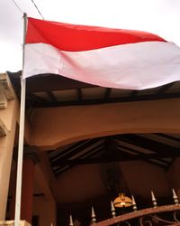 Low angle view of flag against built structure