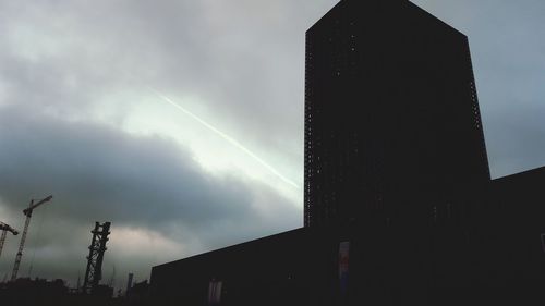 Low angle view of buildings against cloudy sky