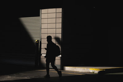 Side view of man standing against wall
