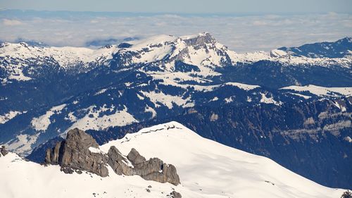 Scenic view of snow covered mountains against sky