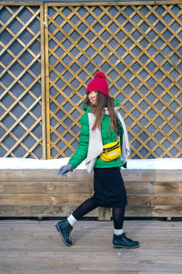 Full length of woman wearing hat standing in snow