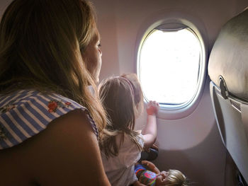 Rear view of woman sitting in airplane