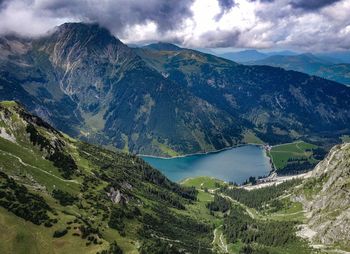 Scenic view of mountains and river against cloudy sky