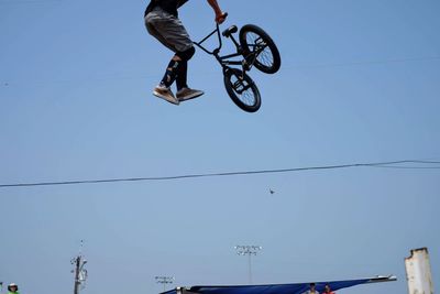 Low angle view of man riding motorcycle against clear sky