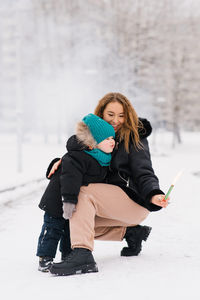 Portrait of smiling woman sitting on snow