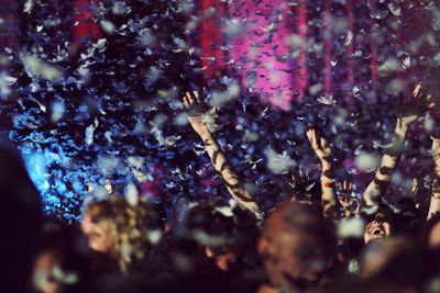 People surrounded by feathers during party