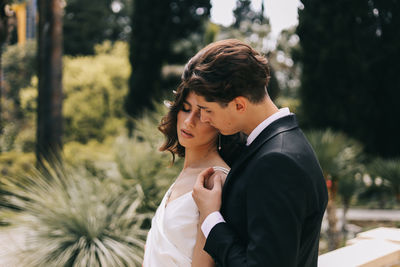 A beautiful couple in love, bride and groom in wedding clothes, walk and pose in the park in nature