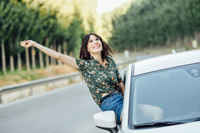 Young woman smiling while standing on road