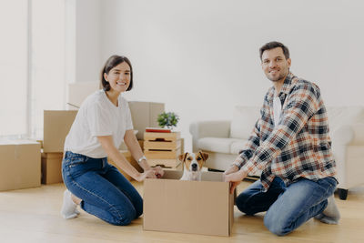 Portrait of couple holding cardboard box