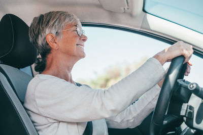 Side view of man using mobile phone while sitting in car