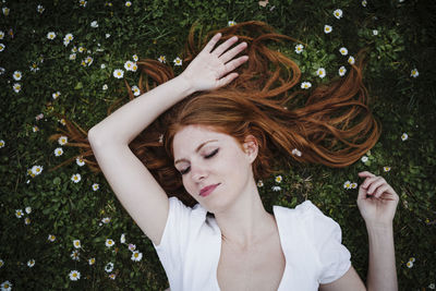 Portrait of young woman lying on plants